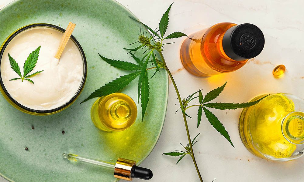 Blog - Cannabis Products Including CBD Oil, Mosterizer, and Pills Laying on a Table